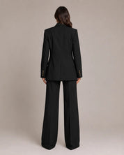 Damesblazer zwart achteraanzicht met revers en knopen; mouwdetails, bijpassende broek