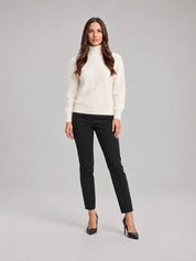 Beige coltrui met lange mouwen en zachte gebreide stof, vrouw in draagstand.