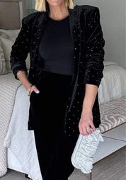 Zwarte fluwelen blazer met V-hals en strass steentjes, lange mouwen.