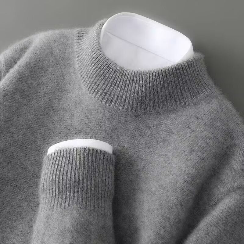 A grey knitted round-neck jumper with long sleeves, a ribbed hem and cuffs.