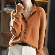 A rust brown knitted cardigan with a collar, button fastening and long sleeves