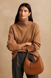 A plain brown women's knitted roll-neck jumper with long sleeves