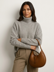 A plain grey women's knitted roll-neck jumper with long sleeves