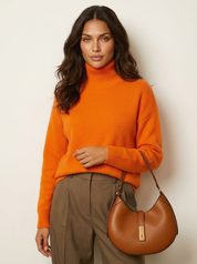 A plain orange women's knitted roll-neck jumper with long sleeves