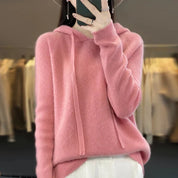 A light pink women's knitted hoodie with a drawstring hood.