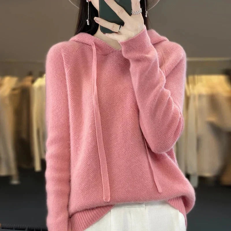 A light pink women's knitted hoodie with a drawstring hood.