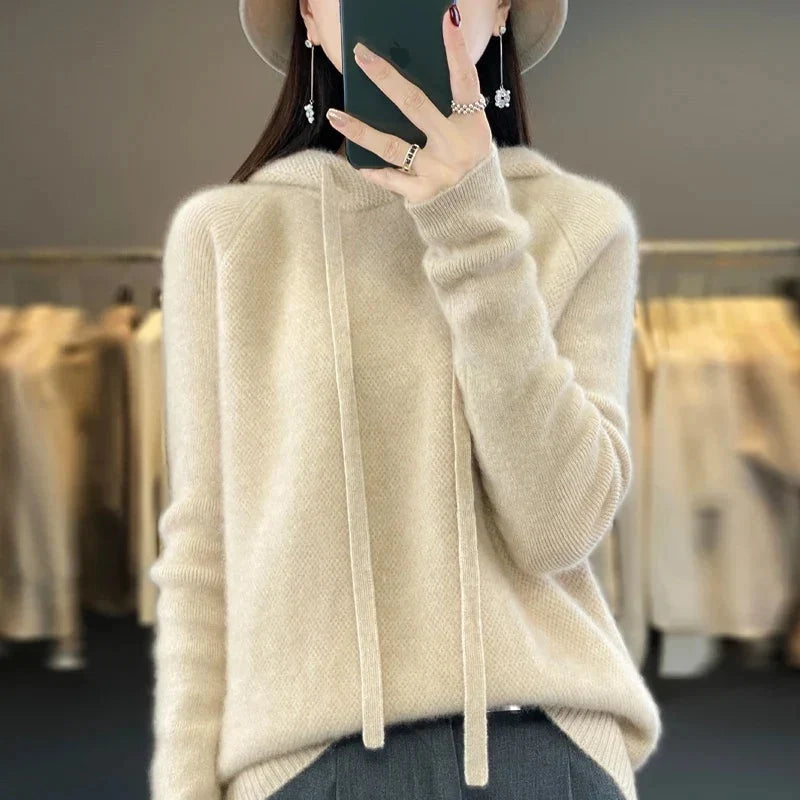 A ivory/beige women's knitted hoodie with a drawstring hood.