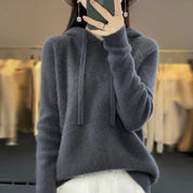 A dark grey women's knitted hoodie with a drawstring hood.