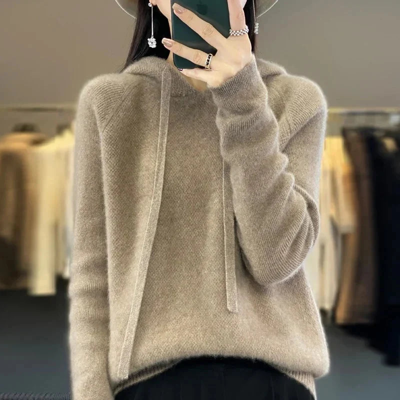 A light beige women's knitted hoodie with a drawstring hood.