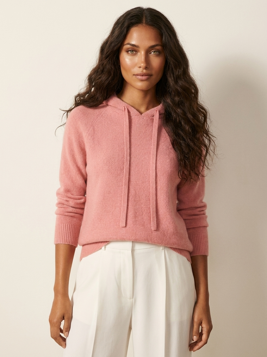 A pink women's knitted hoodie with a drawstring hood and ribbed cuffs