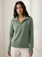 A mint green women's knitted half-zip jumper with a stand collar and long sleeves