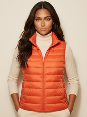 A orange padded gilet with a high collar and zip