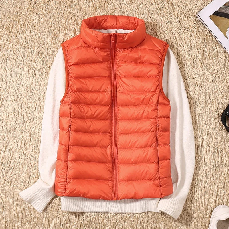 A orange padded women's gilet with a high collar and front zip.