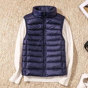 A dark blue padded women's gilet with a high collar and front zip.