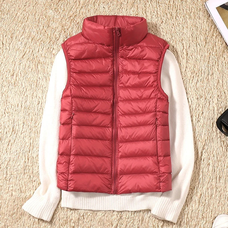 A red padded women's gilet with a high collar and front zip.