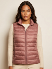 A rose-pink padded women's gilet with a high collar and zip