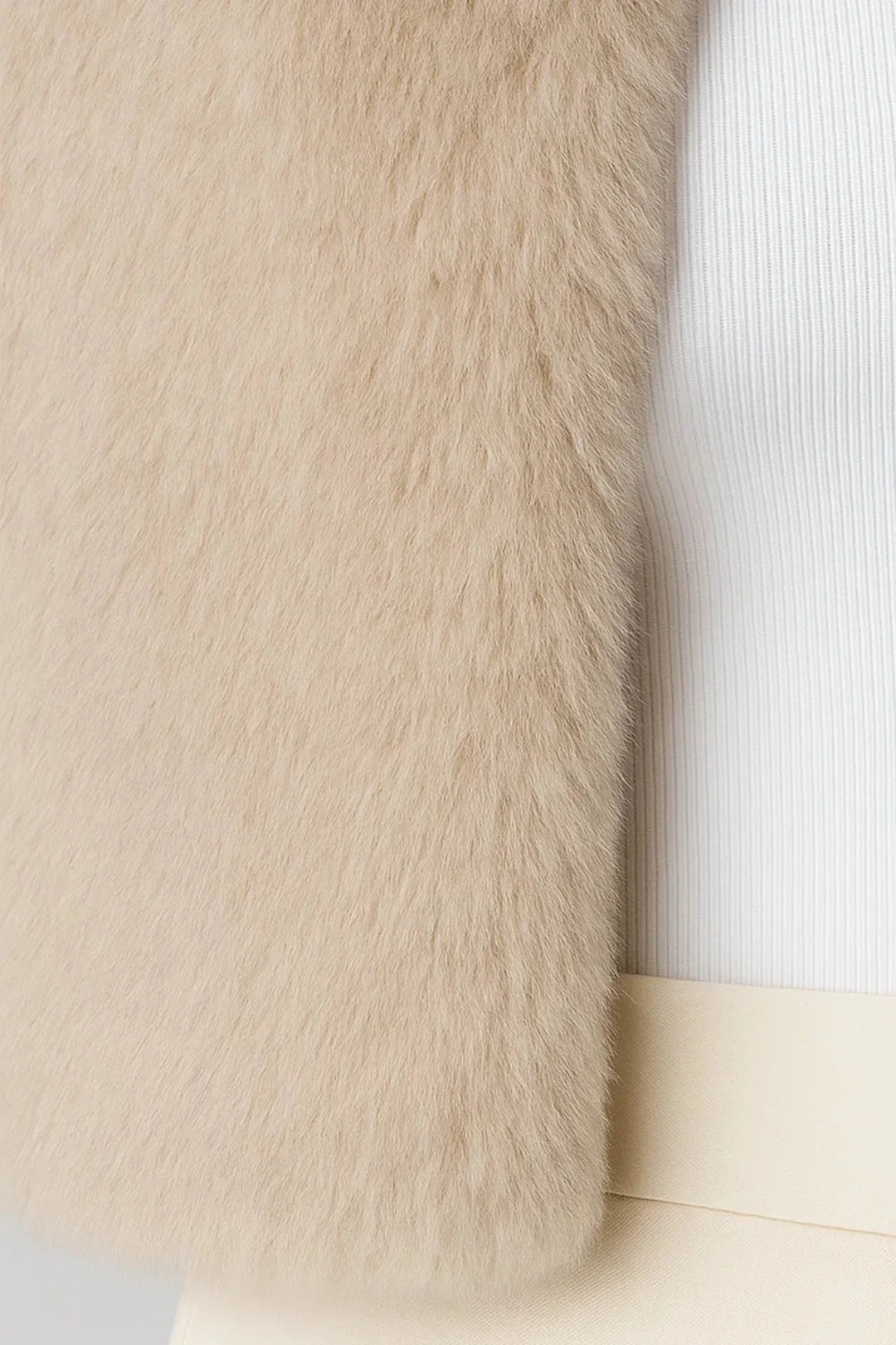 A cropped beige furry jacket, close-up of the soft fur texture at the hem