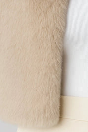 A cropped beige furry jacket, close-up of the soft fur texture at the hem