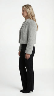 A cropped grey furry jacket with long sleeves, side view
