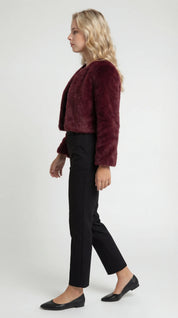 A cropped burgundy furry jacket with long sleeves, side view