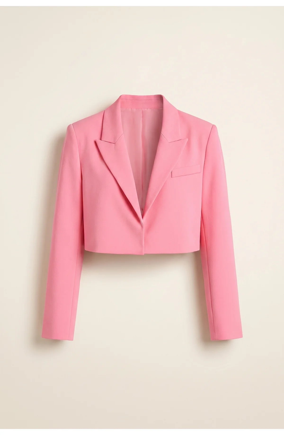 A cropped pink blazer with long sleeves and a V-shaped back, rear view