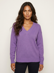 A loose-fitting lilac knitted V-neck jumper with long sleeves.