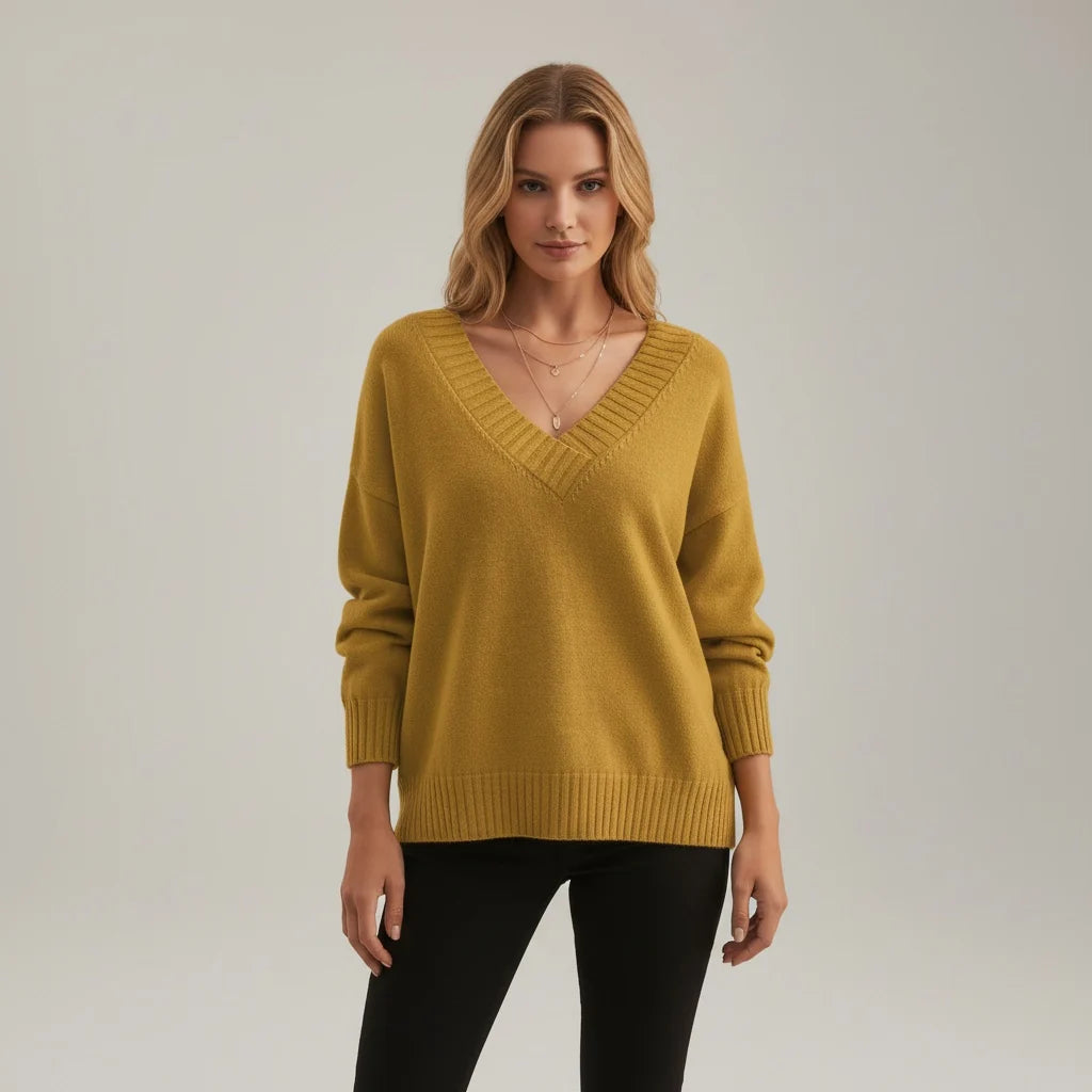 A loose-fitting golden-yellow women's knitted V-neck jumper with long sleeves