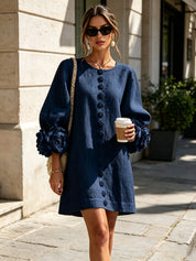 Tuniekjurk met ballonmouwen en roosapplicaties, donkerblauwe jurk met knoopsluiting.