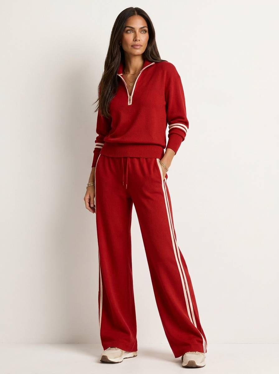 A red women's two-piece sports set with a zip-up jumper and wide-leg trousers with white stripes