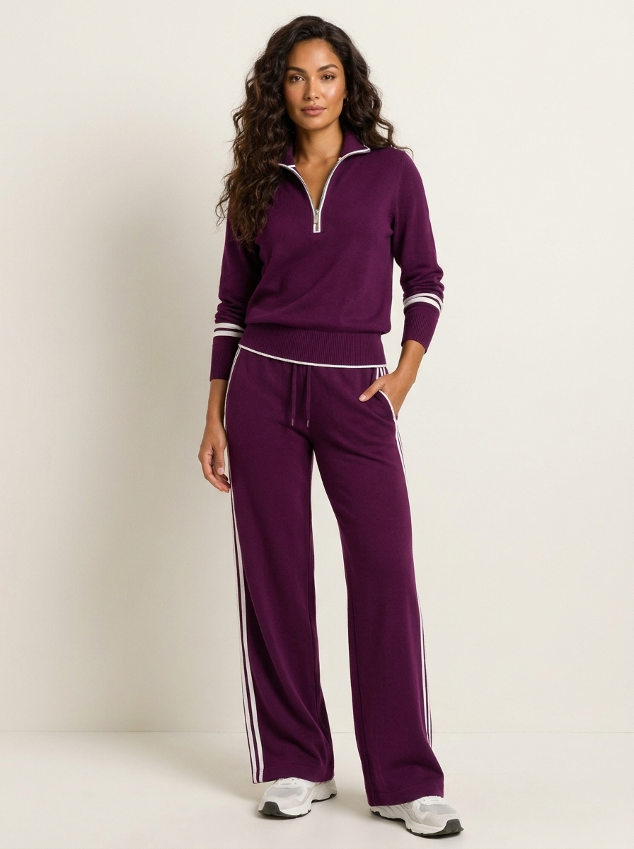 A purple women's two-piece sports set with a zip-up jumper and wide-leg trousers with white stripes