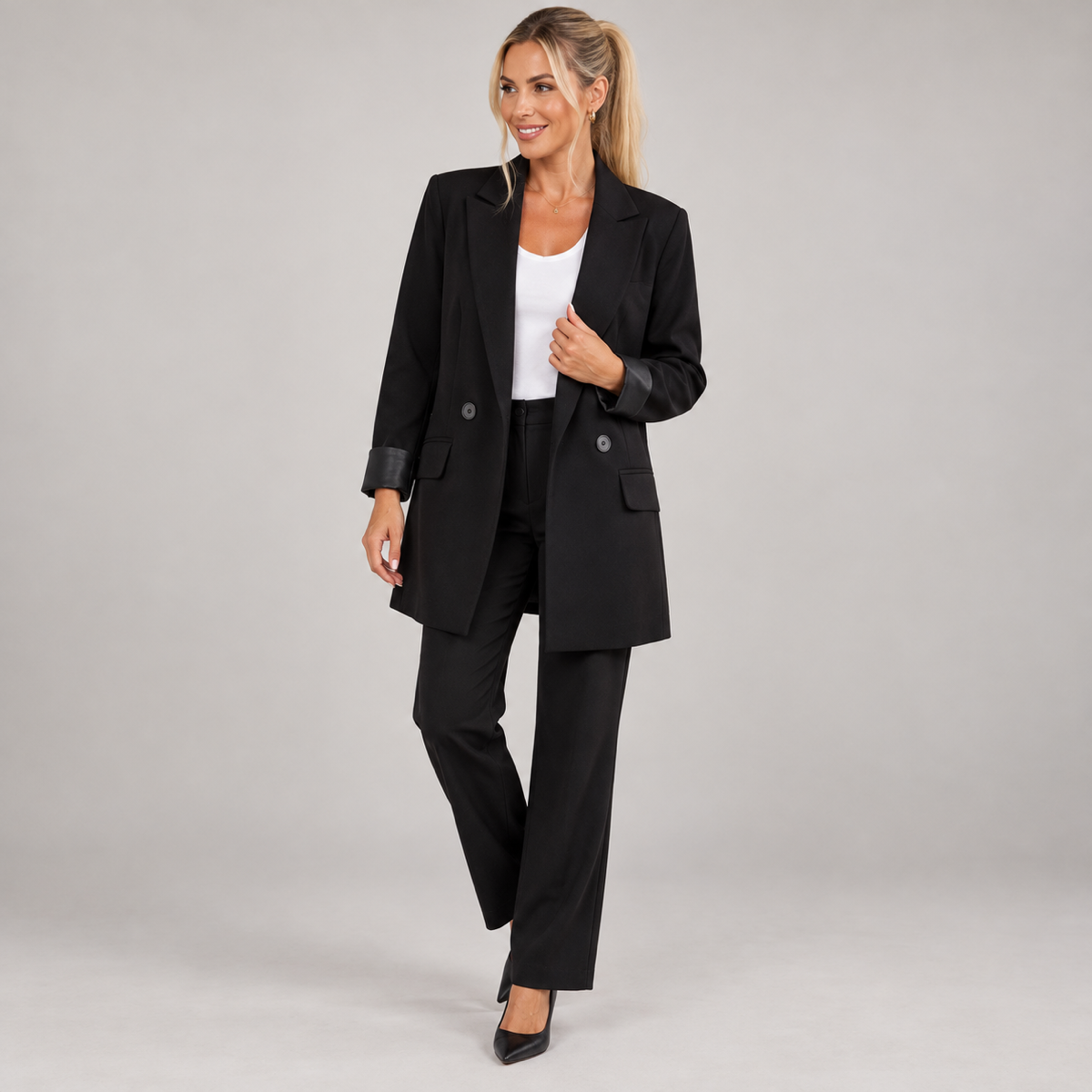 Women's black long oversized double-breasted blazer, worn by a female model, angled front view