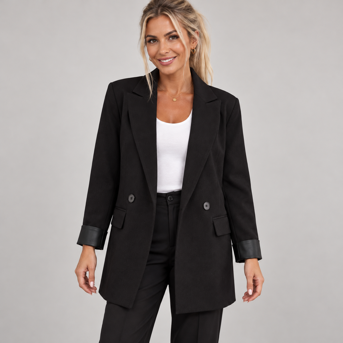 Women's black long oversized double-breasted blazer, worn by a female model, close-up