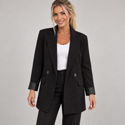 Women's black long oversized double-breasted blazer, worn by a female model, close-up