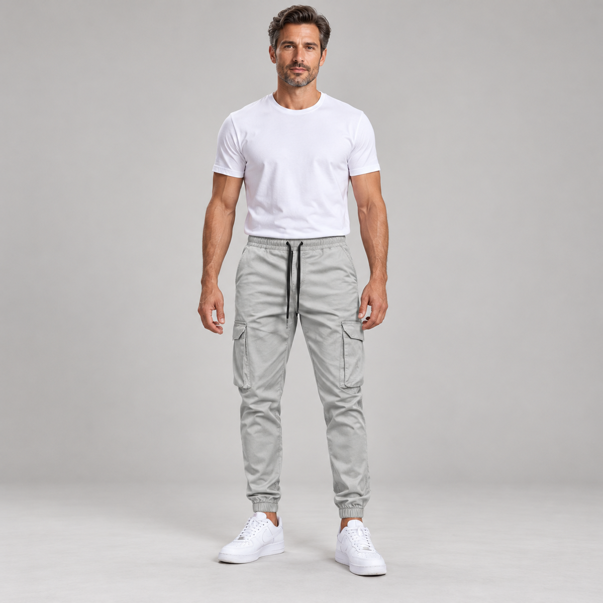 Men's slim-fit joggers with an elastic waistband, worn by a male model, front view