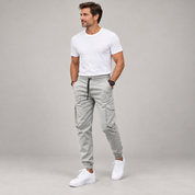 Men's slim-fit joggers with an elastic waistband, worn by a male model, angled front view