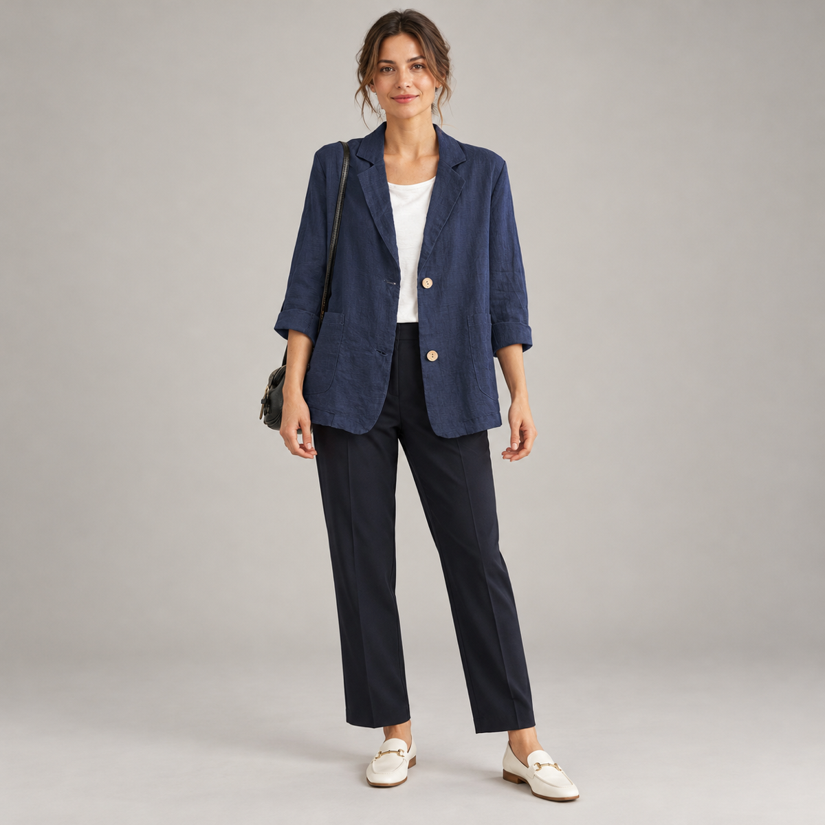 Women's loose-fit blazer with two buttons and roll-up sleeves, worn by a female model, front view