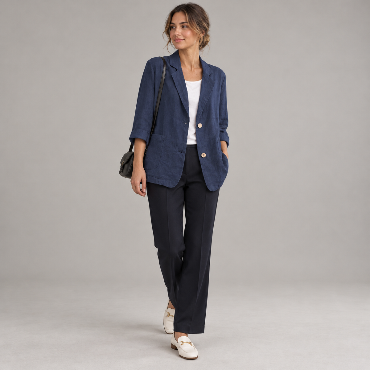 Women's loose-fit blazer with two buttons and roll-up sleeves, worn by a female model, angled front view