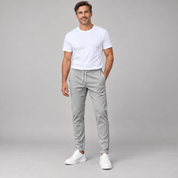 Men's classic tailored trousers with a neat fit, worn by a male model, close-up