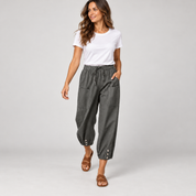 Tapered pantalon dames met trekkoord en diepe zakken op damesmodel, in een lopende pose