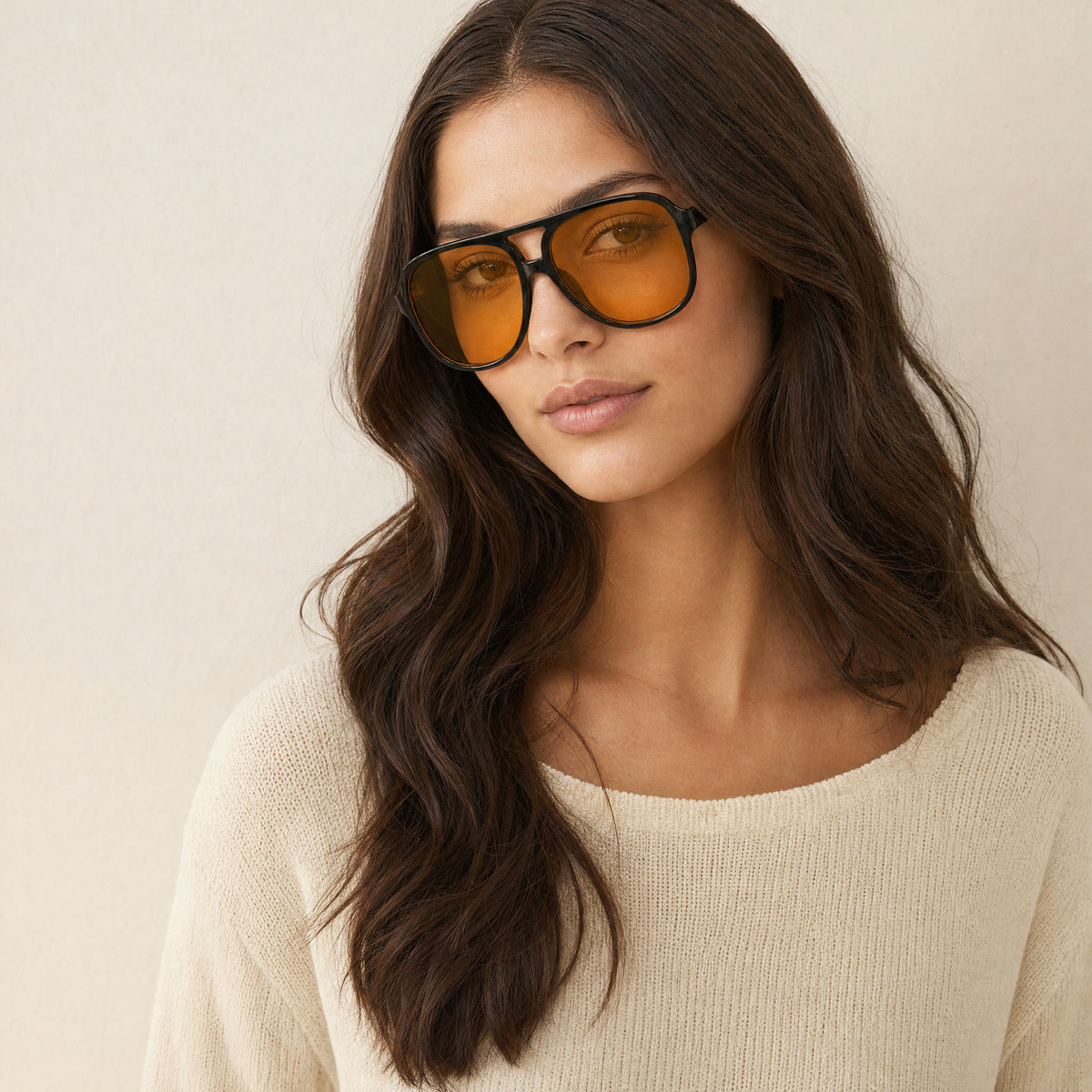 Model met aviator zonnebril met zwart montuur en oranje glazen