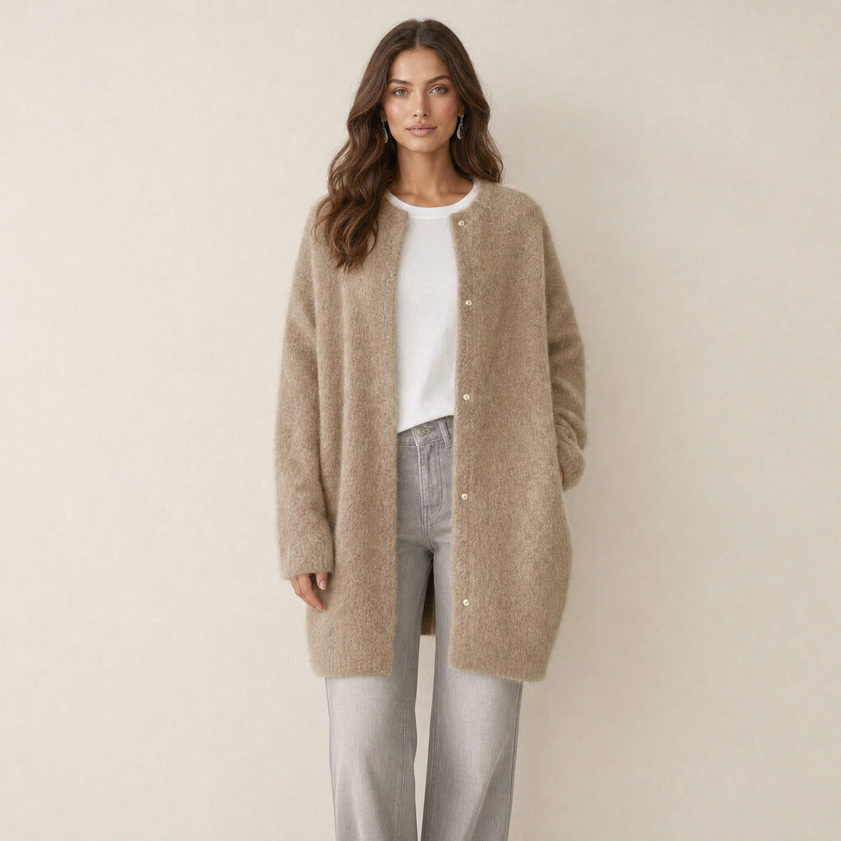 Model in beige oversized gebreid damesvest met knoopsluiting, vooraanzicht
