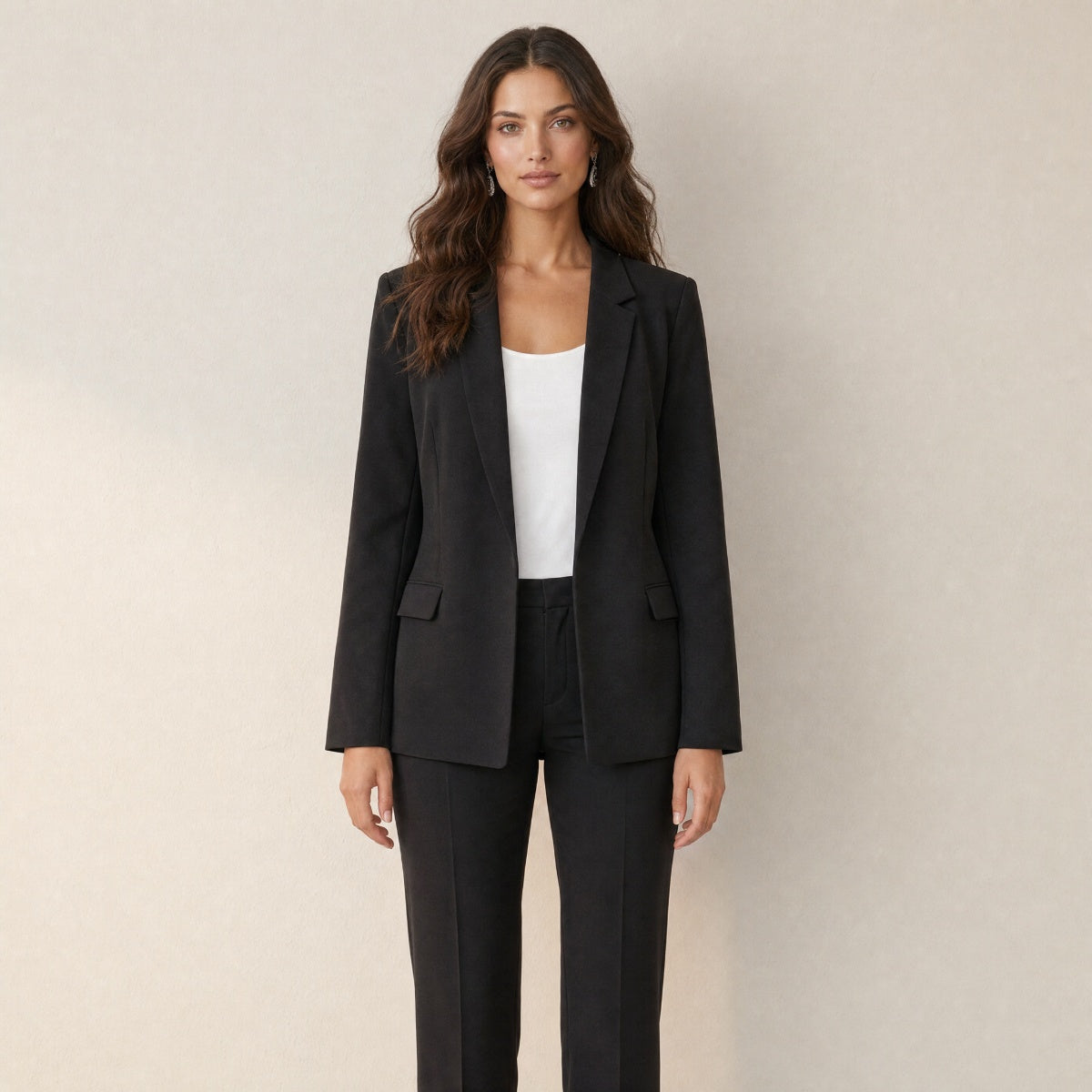 A model wearing a slim-fit black women's blazer, front view