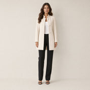 A model wearing a long cream women's collarless blazer, front view