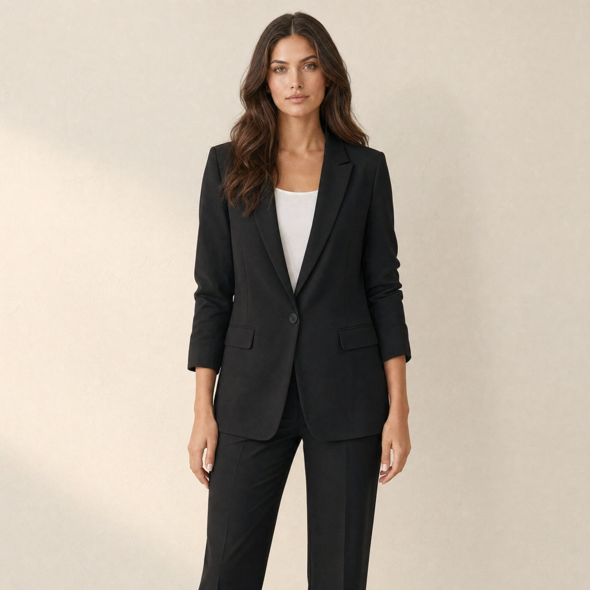 A model wearing a tailored black women's blazer with lapels, front view