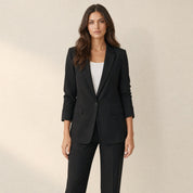 A model wearing a tailored black women's blazer with lapels, front view