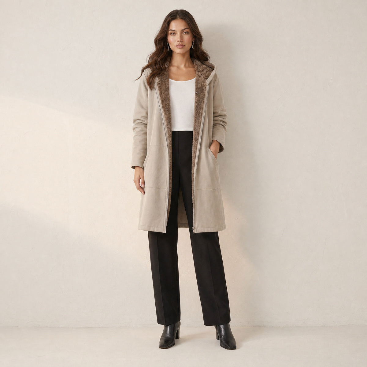 Model in lange beige winterjas met capuchon en teddyvoering, vooraanzicht