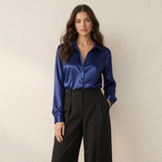 Model in donkerblauwe satijnen damesblouse met lange mouwen en losse pasvorm, vooraanzicht