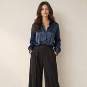 Model in donkerblauwe satijnlook damesblouse met klassieke kraag, losvallend, vooraanzicht