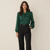 Model in groene strikblouse voor dames met ballonmouwen, losvallend, vooraanzicht