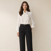 Model in witte strikblouse voor dames met ballonmouwen, losvallend, vooraanzicht